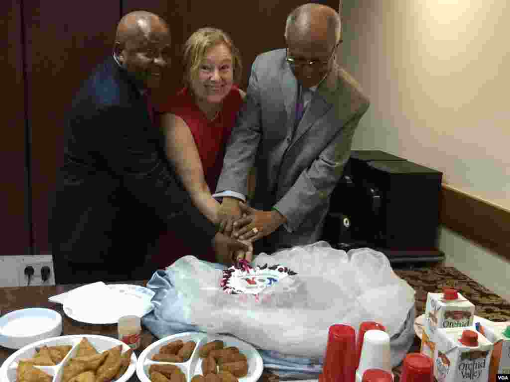 VOA Swahili Service Chief Mwamoyo Hamza, Director Amanda Bennett, and VOA Africa Division Director Negussie Mengesha join hands to cut the cake at the opening celebration of VOA's Studio in Mombasa, Kenya.