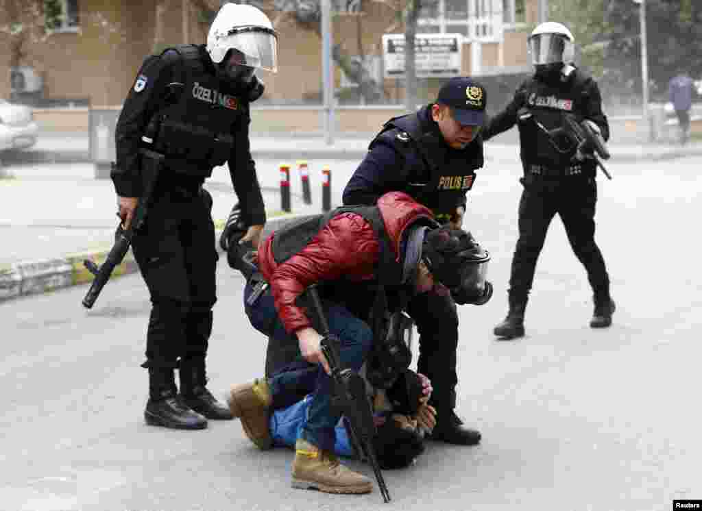 Riot police detain a pro-Kurdish demonstrator during a gathering to celebrate the spring festival of Newroz despite a ban from the governorship, in Istanbul, Turkey.