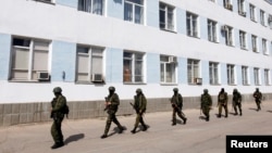 Những người đàn ông vũ trang, được cho là lính Nga, bên trong trụ sở hải quân Ukraina ở Sevastopol, Crimea, ngày 19/3/2014.