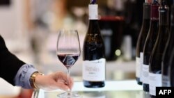 Seorang peserta pameran mencoba minuman anggur di pameran Vinexpo di Javits Center, New York, Senin, 2 Maret 2020. (Foto: AFP)