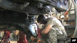 A National Guard soldier in Robbins, Illinois repairs a military Humvee