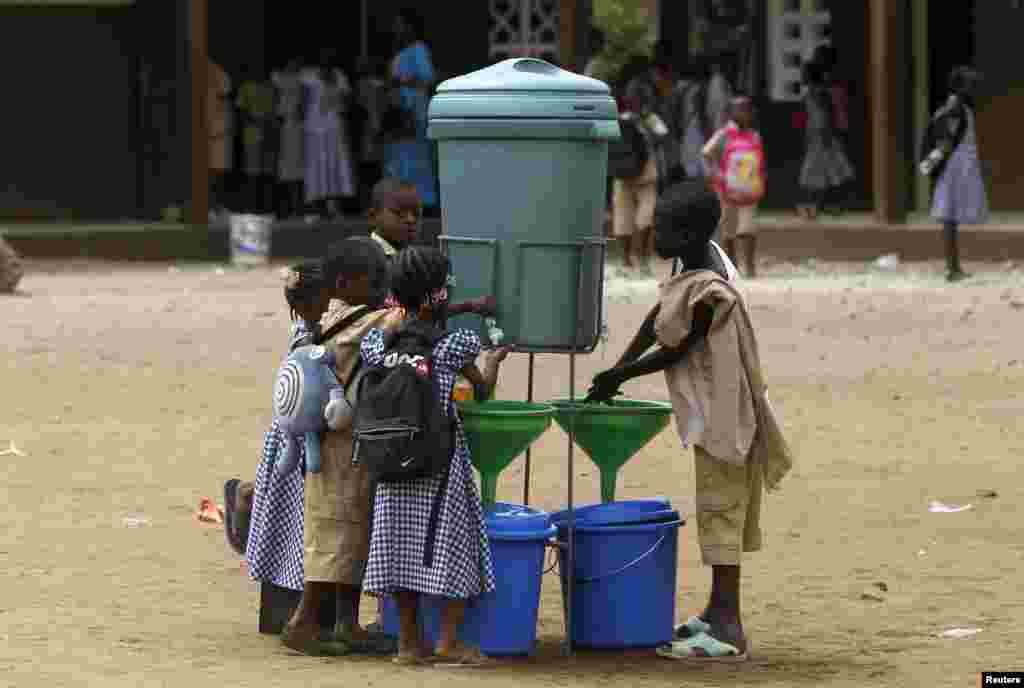 Wanafunzi wanakosha mikono kama hatua ya king dhidi ya Ebola katika shule ya Anono, Abidjan, Ivory Coast, Sept. 25, 2014. 