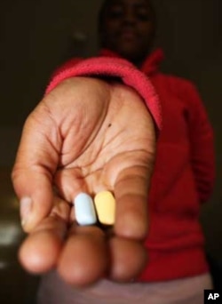 Bernice holds the antiretroviral pills she has to take every night. She says she"hates" them, but knows they keep her alive
