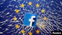 FILE - An illustration shows a 3-D-printed Facebook logo placed on broken glass above a printed EU flag.