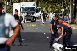 French police secure the area as the investigation continues at the scene near the heavy truck that ran into a crowd at high speed killing scores who were celebrating the Bastille Day July 14 national holiday on the Promenade des Anglais in Nice, France.