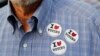 FILE - A man wears stickers after casting his ballot at the Hamilton County Board of Elections in Cincinnati, Oct. 10, 2018. In addition to choosing candidates, voters are deciding ballot initiatives.