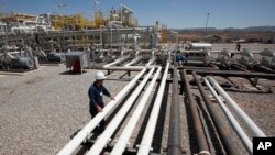 FILE - An employee works at an oil field in the Kurdish region in northern Iraq.