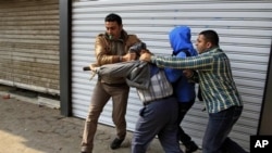 Plainclothes policemen arrest supporter of ousted Egyptian President Mohammed Morsi during clashes in Cairo, Jan. 3, 2014.