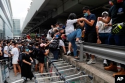 Manifestantes prodemocracia se retiran después que la policía antidisturbios llega a las afueras del aeropuerto de Hong Kong, el domingo 1 de septiembre de 2019.
