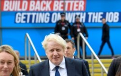Britain's Prime Minister Boris Johnson walks through the Conservative Party annual conference venue, in Manchester, Britain, Oct. 3, 2021.