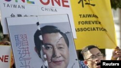 Aktivis Taiwan mengangkat spanduk bergambar wajah yang Presiden Taiwan Ma Ying-jeou yang dikombinasikan dengan wajah Presiden China Xi Jinping, dalam aksi protes di Taipei, Taiwan (6/11).