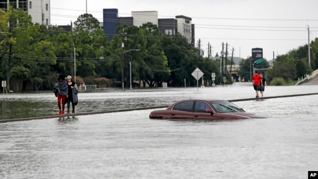 Người dân Houston đi qua vùng nước ngập hôm 27/8.