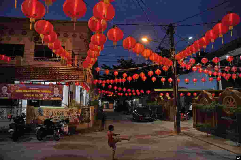 A young boy plays under lanterns at the Hok Lay Kiong temple on the Lunar New Year, in Bekasi, Indonesia.