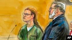 In this courtroom sketch, Maria Butina, left, is shown next to her attorney Robert Driscoll, before U.S. District Judge Tanya Chutkan, during a court hearing at the U.S. District Court in Washington, Dec. 13, 2018.