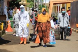 Warga yang dinyatakan sembuh meninggalkan Asrama Haji Surabaya yang dipergunakan untuk isolasi dan perawatan pasien positif corona (foto Humas Pemkot Surabaya).
