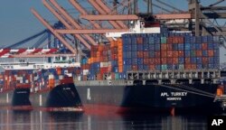 FILE - In this Feb. 23, 2015 file photo, container ships wait to be unloaded at the Port of Los Angeles.