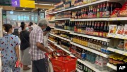 FILE - People buy food and other grocery items at a supermarket in Yangon, Myanmar, Sept. 7, 2021.