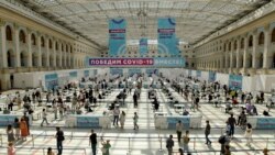 People wait in line for a COVID-19 vaccine at a vaccination center in Gostinny Dvora, a huge exhibition place in Moscow, Russia, as the country faces a sharp surge in coronavirus cases.