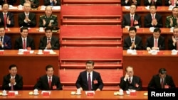 FILE - Chinese President Xi Jinping, center, attends the opening of the 19th National Congress of the Communist Party of China at the Great Hall of the People in Beijing, China, Oct. 18, 2017.