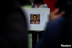 An activist holds a picture of Wanchalearm Satsaksit, 37, a Thai political activist who was abducted by unknown gunmen in front of his Phnom Penh apartment, during a protest for his disappearance in Bangkok, Thailand, June 5, 2020.