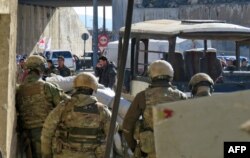 Russian soldiers gather in the government-held side of the embattled city of Aleppo before the start on an evacuation operation of rebel fighters and their families from rebel-held areas on Dec. 15, 2016.