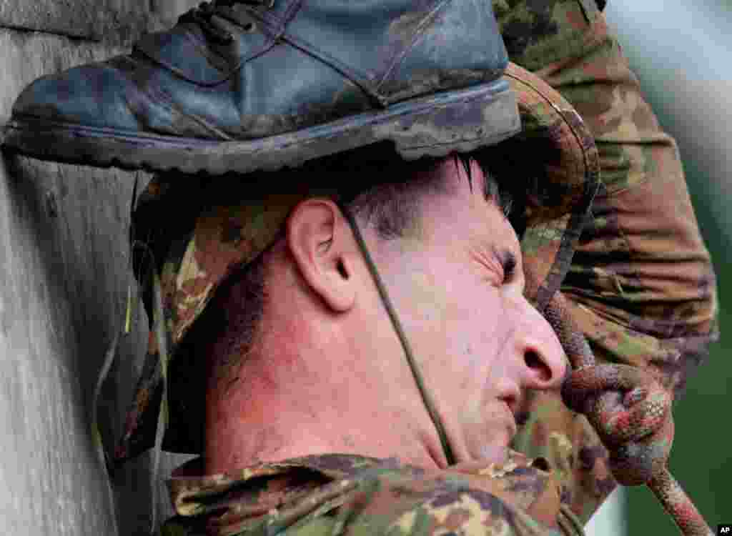 An Armenian soldier grimaces during his team's effort during the Army Scout Masters competition, part of Army Games, outside Novosibirsk, 2,900 kilometers (some 1,800 miles) east of Moscow, Russia, Aug. 2, 2017.