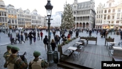 Belgian soldiers stand guard at Brussels' Grand Place, Dec. 30, 2015, after two people were arrested in Belgium on Sunday and Monday, both suspected of plotting an attack in Brussels on New Year's Eve, federal prosecutors said.