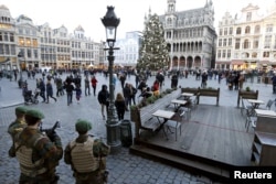 Belgian soldiers stand guard on Brussels' Grand Place, Dec. 30, 2015, after two people were arrested in Belgium on Sunday and Monday, both suspected of plotting an attack in Brussels on New Year's Eve, federal prosecutors said.