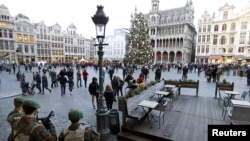 Belgian soldiers stand guard on Brussels' Grand Place, Dec. 30, 2015, after two people were arrested in Belgium on Sunday and Monday, both suspected of plotting an attack in Brussels on New Year's Eve, federal prosecutors said.