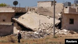 시리아 내전이 3년 넘게 계속되고 있는 가운데 폐허가 된 건물 앞을 한 주민이 걸어가고 있다. (자료 사진)