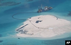 FILE - In this Feb. 25, 2014 photo taken by surveillance planes and released by the Philippine Department of Foreign Affairs, a Chinese vessel, top center, is used to expand structures and land on the Johnson Reef.