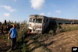 Onlookers gather at the scene of a train collision just outside Egypt’s Mediterranean port city of Alexandria, Aug. 11, 2017.
