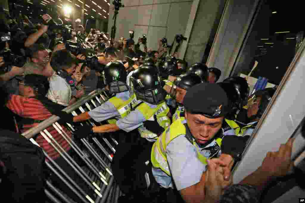 Petugas polisi bentrok dengan para pengunjuk rasa yang menerobos gedung lembaga perwakilan dalam sebuah demonstrasi di Hong Kong. Ratusan penduduk desa dan para mengunjuk rasa menentang penmerintah dalam sebuah rencana pembangunan di Wilayah Baru Timur Laut.