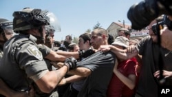 Young Israeli settlers scuffle with Border Police officers over the demolition of a building at the Jewish settlement of Beit El, near the West Bank town of Ramallah, July 29, 2015.