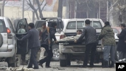 Afghans load a victim, right, into an ambulance at the scene of a suicide car bomb attack in Kabul, Afghanistan, January 16, 2013.