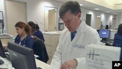 A doctor accesses personalized healthcare information for patients on a computer, February 2011