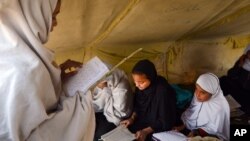 FILE - Afghan students attend class in a tent in Jalalabad, capital of Nangarhar province, Afghanistan, Dec. 16, 2015. Analysts say by targeting students and education centers, militants are aiming at the heart of the society.