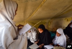 FILE - Afghan students attend class in a tent in Jalalabad, capital of Nangarhar province, Afghanistan, Dec. 16, 2015. Analysts say that by targeting students and education centers, militants are aiming at the heart of the society.