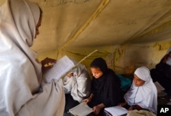 FILE - Afghan students attend class in a tent in Jalalabad, capital of Nangarhar province, Afghanistan, Dec. 16, 2015. Analysts say by targeting students and education centers, militants are aiming at the heart of the society.