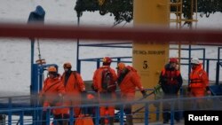 Russian Emergencies Ministry members walk on a pier near the crash site of Russian military Tu-154 plane in the Black Sea in the Sochi suburb of Khosta, Russia, Dec. 25, 2016. 