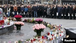 People attend a ceremony at Place de la Republique to pay tribute to the victims of last year's shooting at the French satirical newspaper Charlie Hebdo, in Paris, Jan. 10, 2016.