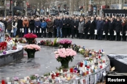 FILE - People attend a ceremony at Place de la Republique square to pay tribute to the victims of the shooting at the French satirical newspaper Charlie Hebdo, in Paris, France, Jan. 10, 2016. Francois Hollande, president at the time of the attack, got a small boost in poopularity for his response to them but ended up finishing his term with record low ratings.