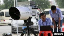 Engineers of Tianjin environmental monitoring center use a device to check the level of hydrogen cyanide present in the air at a monitoring station observing environmental pollution located within a 3-km (2-mile) exclusion zone from last week's explosion 