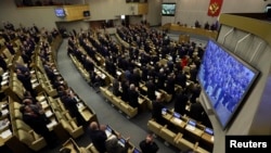 FILE - Russian deputies applaud during voting in the Duma, Russia's lower house of parliament, in Moscow, March 20, 2014.