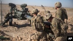FILE - U.S. soldiers ready a howitzer to be towed into position at Bost Airfield in Afghanistan's Helmand Province in this June 10, 2017 photo provided by Operation Resolute Support.