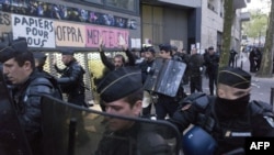 Nhân viên cảnh sát hộ tống người biểu tình ủng hộ di dân ra khỏi cuộc tuần hành phản đối việc cảnh sát buộc di dân rời khỏi trường trung học Jean-Jaures, ngày 4/5/2016.