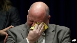 Former priest James Faluszczak, who says he was molested by a priest as a teenager, reacts as Pennsylvania Attorney General Josh Shapiro speaks during a news conference at the Pennsylvania Capitol in Harrisburg, Pa., Aug. 14, 2018. A Pennsylvania grand jury says its investigation of clergy sexual abuse identified more than 1,000 child victims.