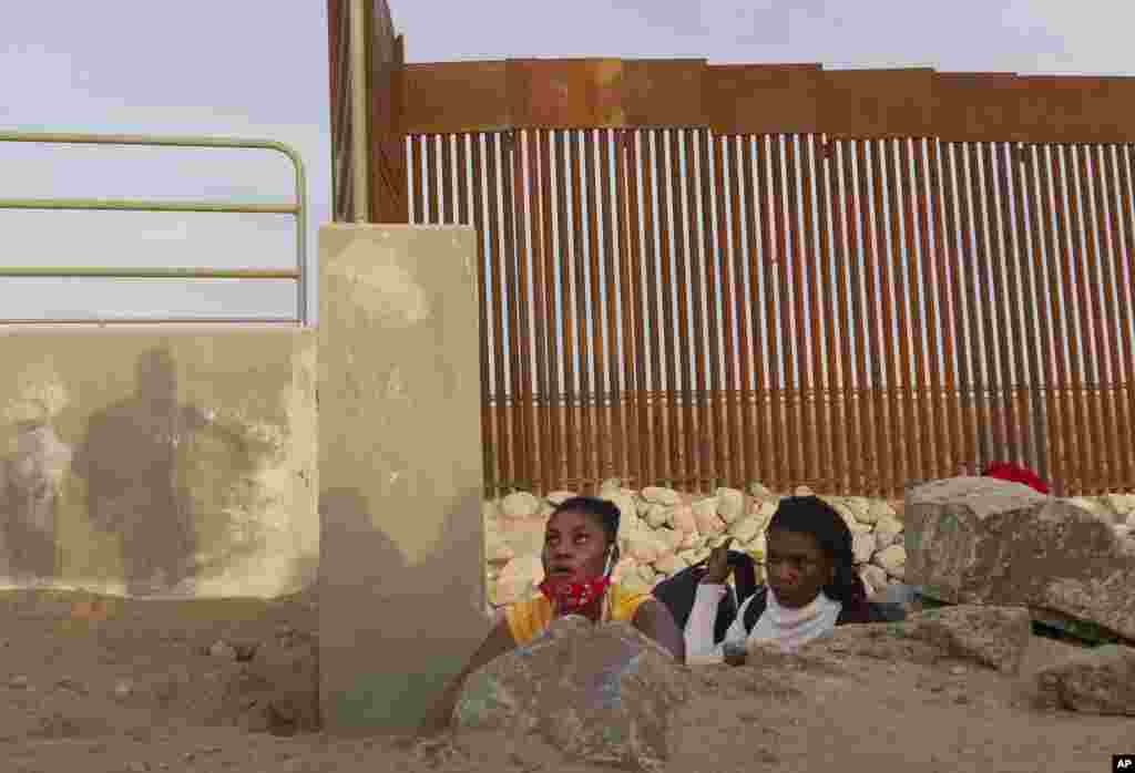 A Haitian migrant family looks to emerge from a rocky canal adjacent to a gap in the U.S. border wall in Yuma, Arizona, June 9, 2021.
