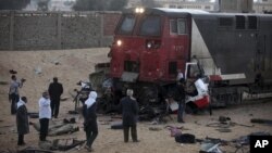 Wartawan dan warga memeriksa kendaraan yang tertabrak kereta api di dekat desa Dahshur, 40 kilometer dari Kairo, Mesir (18/11).