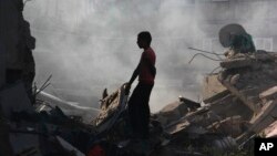 Seorang warga Gaza berusaha mencari barang-barang berharga di antara reruntuhan rumahnya (14/8).